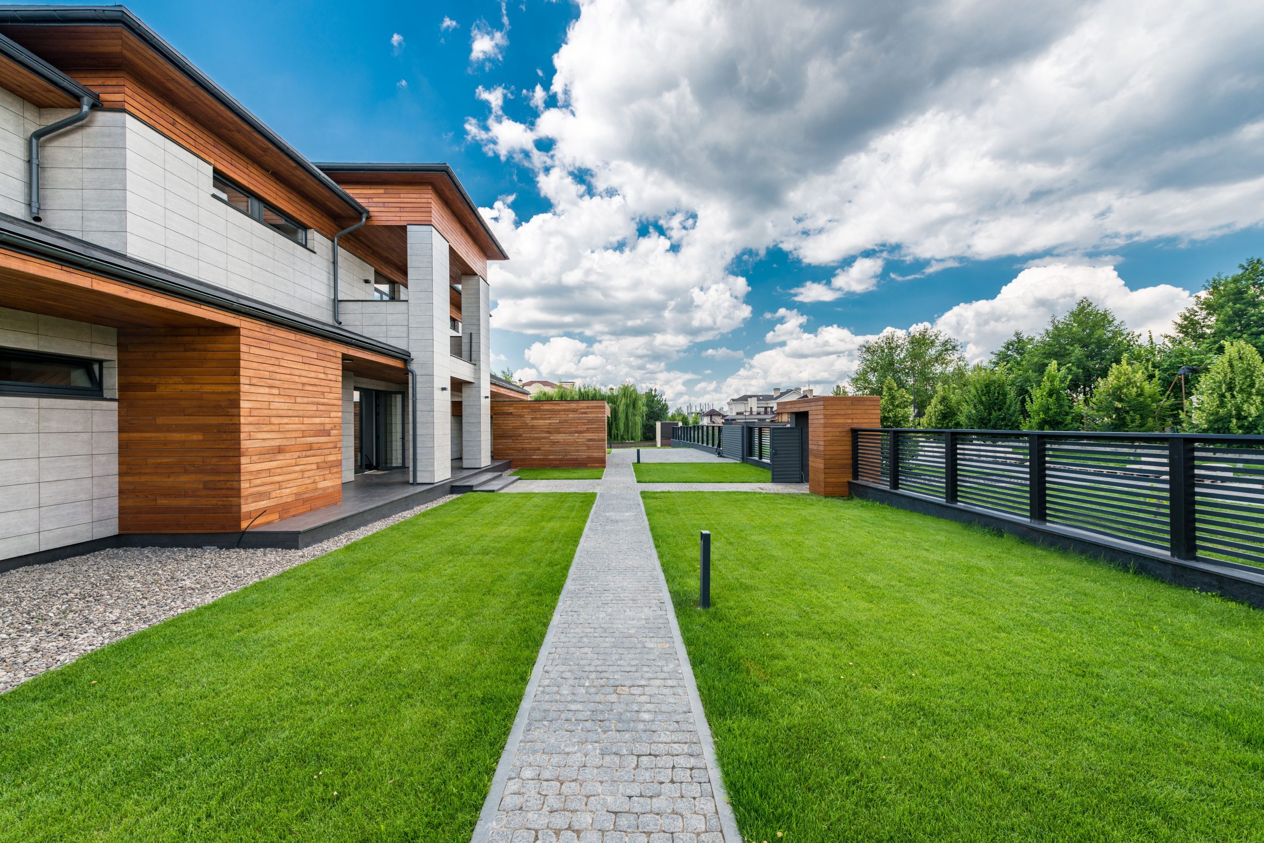 Jardin verdoyant maison moderne avec clôture et arbres