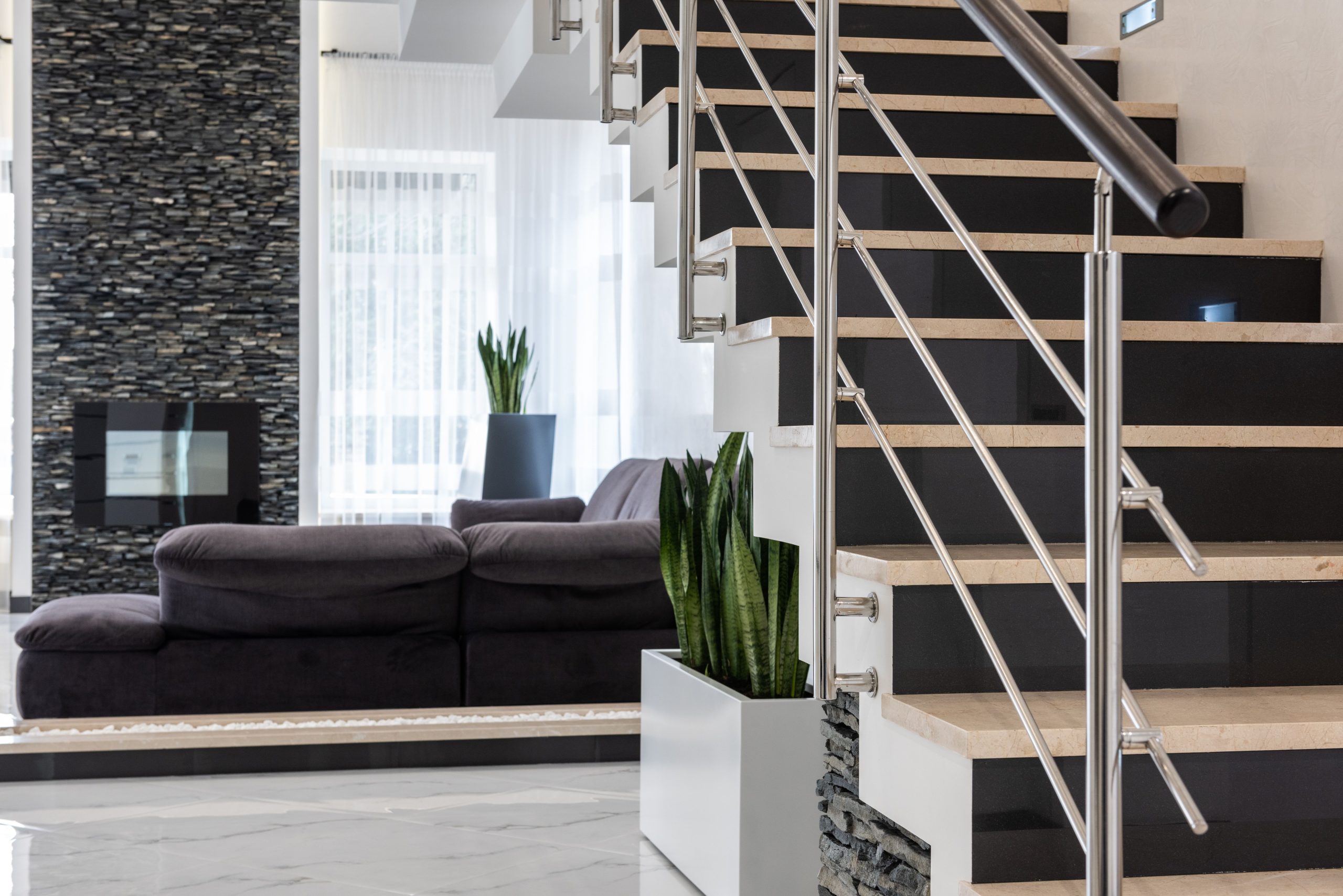 Salon spacieux avec escalier et plantes décoratives