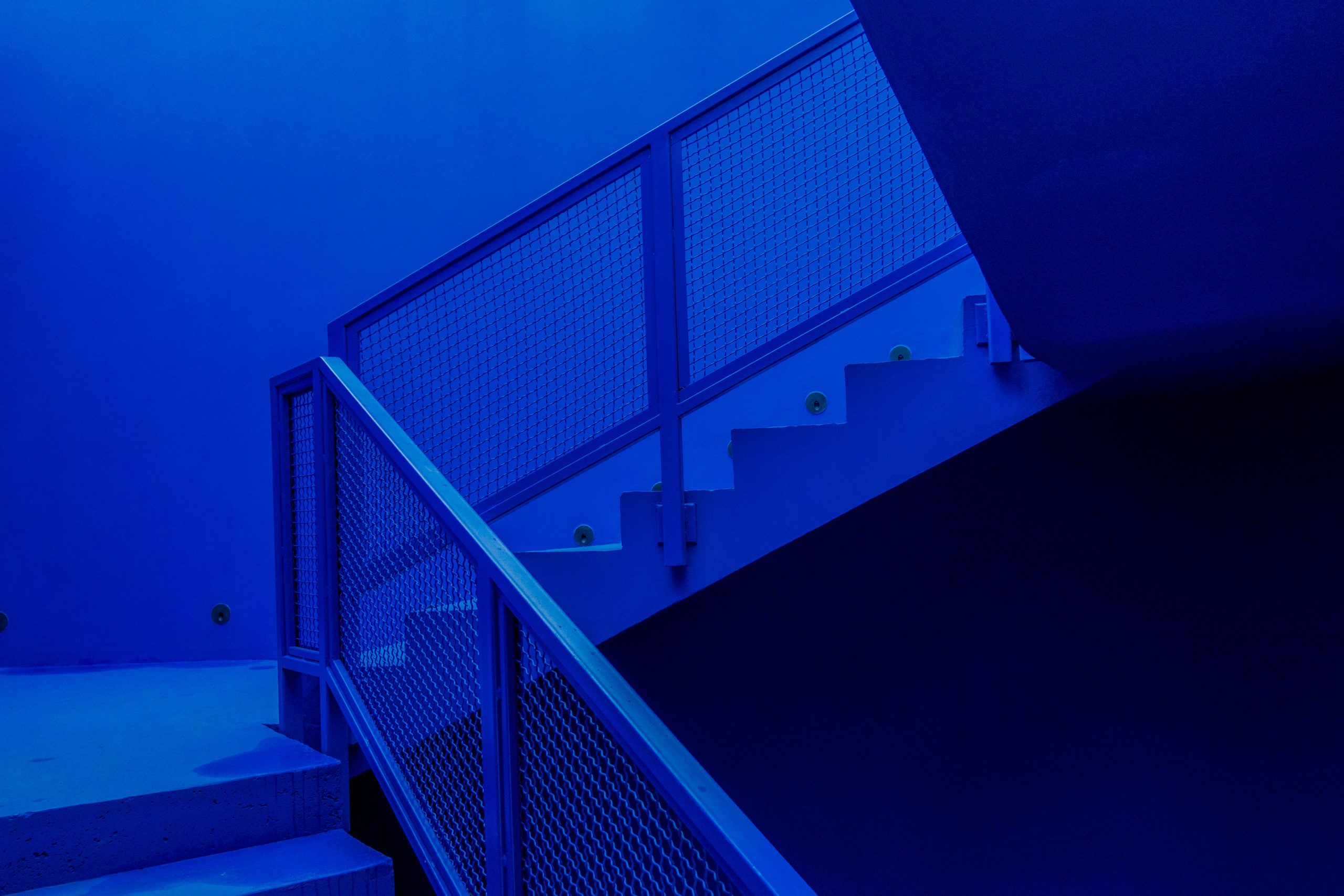 Escalier minimaliste avec rampe métallique néon bleu