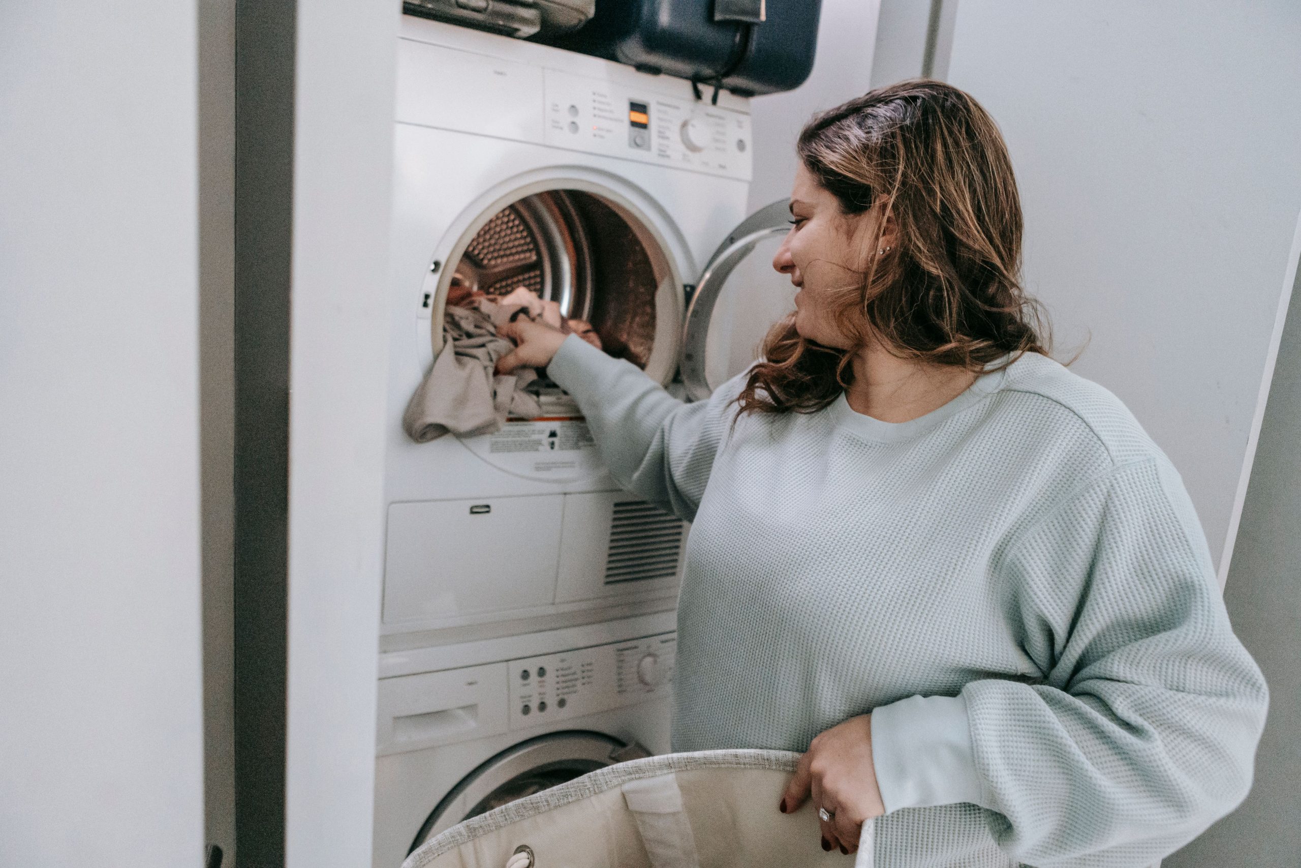 Femme chargeant du linge dans machine moderne